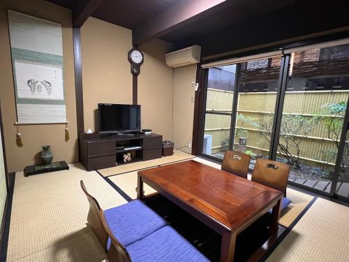 a dining room with a table and a clock on the wall at Maeniiya Machiya Inn in Kyoto