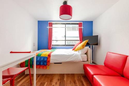 a small bedroom with a bed and a red chair at 浅草橋201 in Tokyo