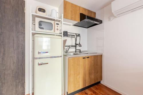 a small kitchen with a refrigerator and a microwave at 浅草橋201 in Tokyo