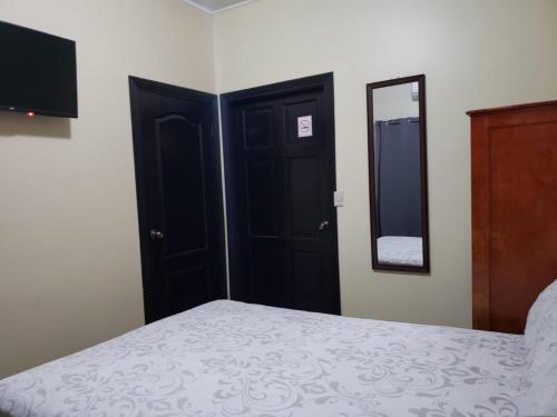 a bedroom with a bed and a mirror at Casa Altamira in San Pedro Sula