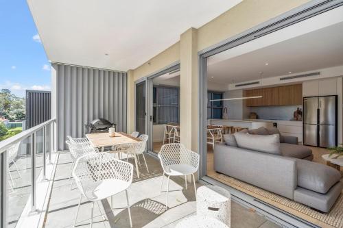 a balcony with a couch and a table and chairs at Family-Friendly 3BR - Steps from the Beach in Huskisson