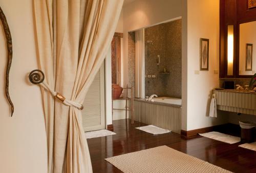 a bathroom with a shower curtain and a bath tub at Residence 7 at the Four Seasons Resort in Mae Rim