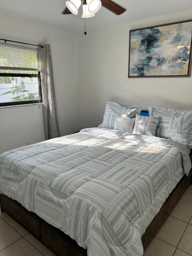 a large bed in a bedroom with a ceiling fan at Peaceful Home in Central Florida Near Universal in Orlando