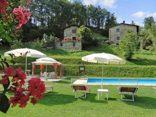 un groupe de chaises et de parasols dans une cour dans l'établissement Private Garden House in Redortiers, à Redortiers