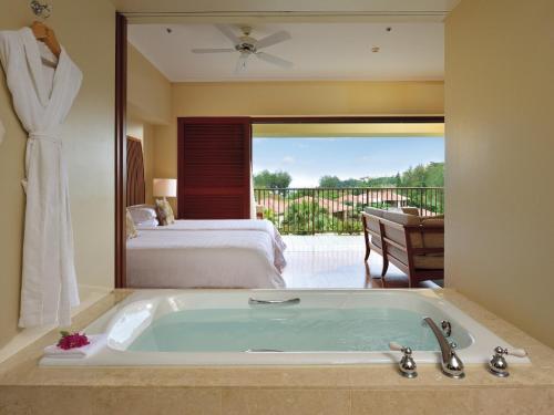 a bath tub in a room with a bedroom at The Terrace Club Wellness Thalasso At Busena in Nago