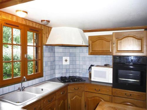 una cocina con fregadero y microondas en Wooden House by Beach near Barneville, en Denneville
