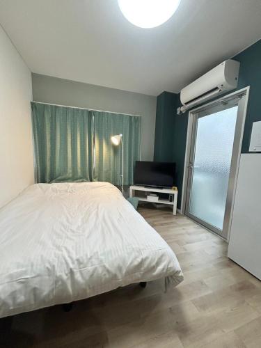 a bedroom with a white bed and a window at SABBATH uzumasa 201 in Kyoto