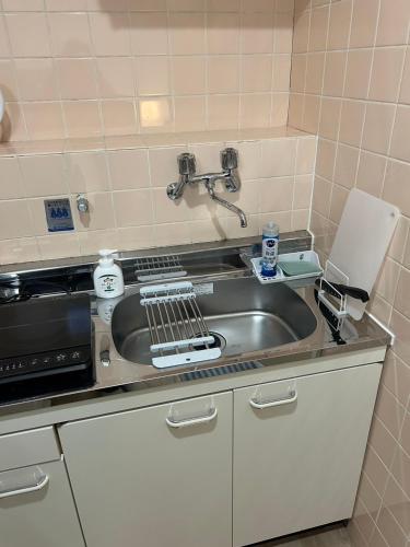 a kitchen with a sink and a microwave at SABBATH uzumasa 201 in Kyoto