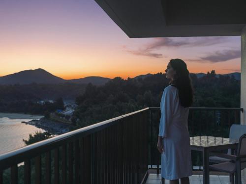 a woman standing on a balcony looking at the sunset at The Terrace Club Wellness Thalasso At Busena in Nago