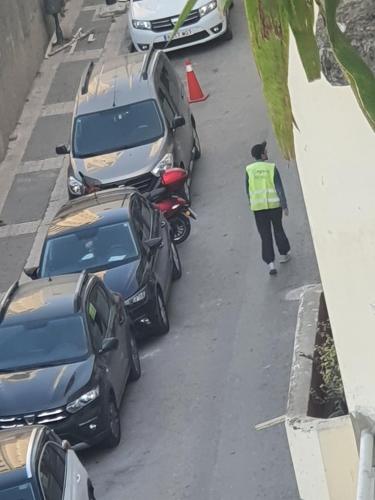 a woman walking down a street next to cars at Hotel Le Gardenia (ex Lutetia) in Tangier