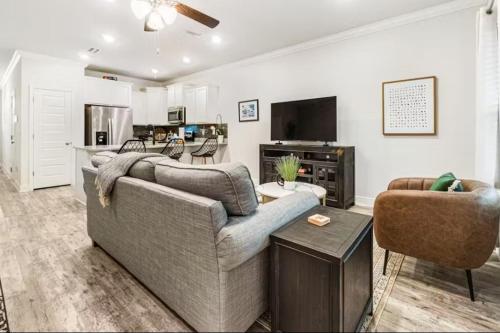 a living room with a couch and a tv at Pensacola Paradise Downtown in Pensacola