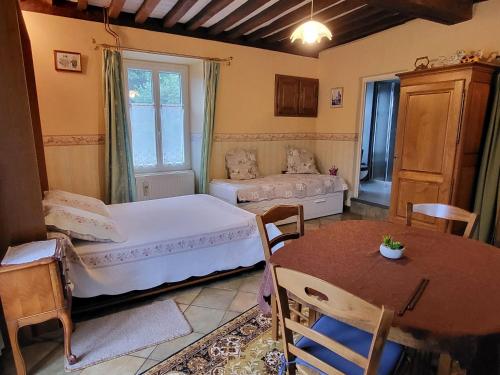 a bedroom with two beds and a table and a table and chairs at Chambres de caractère avec parc fermé et stationnement sécurisé - FR-1-583-278 in Choye