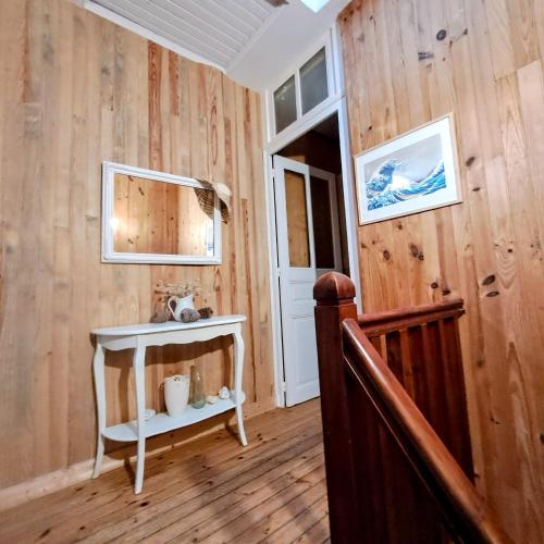une pièce avec des murs en bois et un escalier avec une table blanche dans l'établissement appartement dans la Villa Colibri,, à La Baule