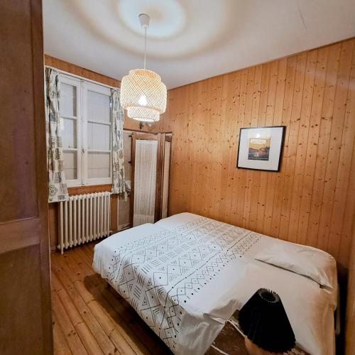 une chambre avec un lit et un lustre dans l'établissement appartement dans la Villa Colibri,, à La Baule