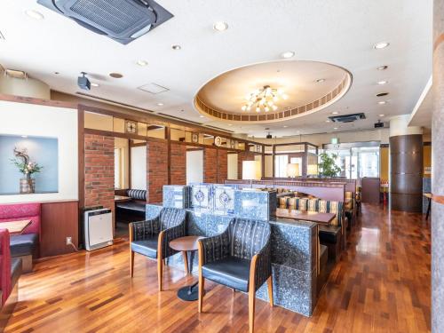 a restaurant with a bar with chairs and tables at Century Plaza Hotel in Tokushima
