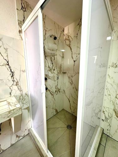 a bathroom with a shower with white marble at Garden and Villas Yami in Coaxuxco