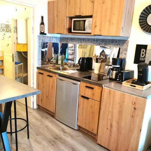 une cuisine avec un évier et un micro-ondes dans l'établissement Appart moderne REVE BLEU Hypercentre Blois à 5 min Château, à Blois