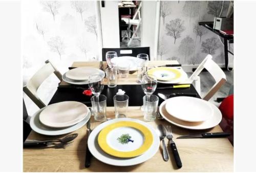 una tavola con piatti bianchi e argenteria di Appart moderne REVE BLEU Hypercentre Blois à 5 min Château a Blois