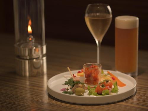 a plate of food and a glass of wine on a table at The Terrace Club Wellness Thalasso At Busena in Nago