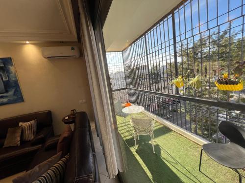 a living room with a large window with a couch and a table at Rabat Agdal Pearl - 2BR Spacious & Well located in Rabat