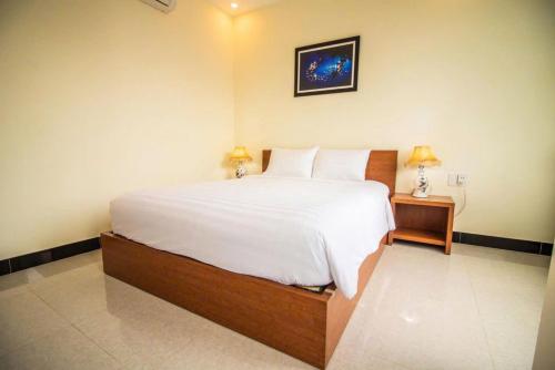 a bedroom with a large bed with white sheets and pillows at Gold Stone Hoi An Homestay in Hoi An