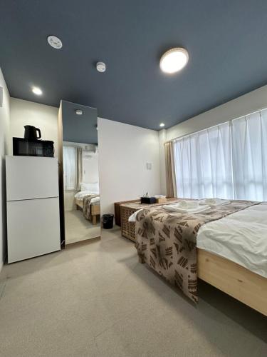 een slaapkamer met een groot bed en een koelkast bij 福ホテル501 in Tokyo