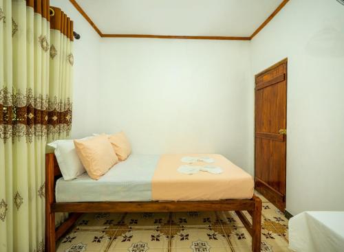 a small bedroom with a bed and a door at Diyaluma NAS Villa in Koslanda