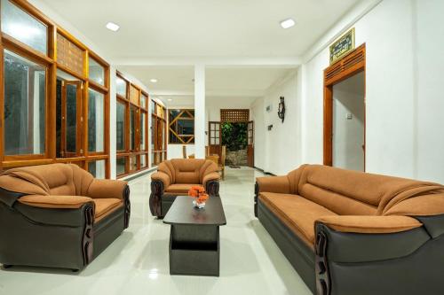 a living room with two couches and a coffee table at Diyaluma NAS Villa in Koslanda