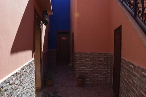 an alley way with a dark door and a wall at Maison Marrakech in Touggana