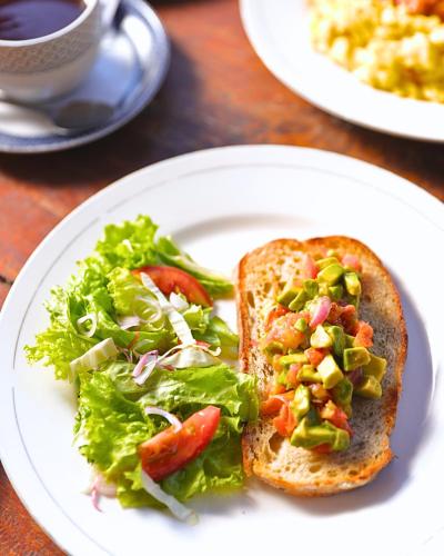 a white plate with a sandwich and a salad at Umahita Lodge Penida in Toyapakeh