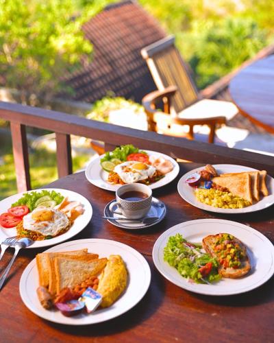 a table with plates of breakfast food on it at Umahita Lodge Penida in Toyapakeh
