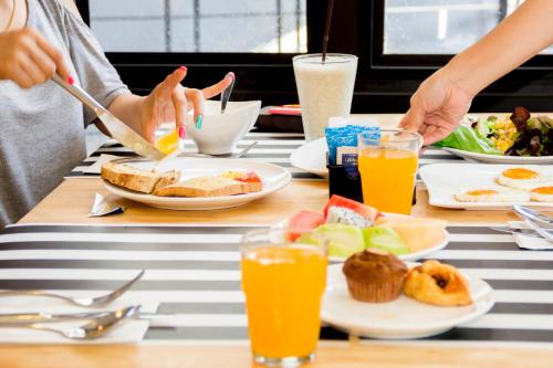 eine Gruppe von Menschen, die an einem Tisch sitzen und Frühstück essen in der Unterkunft Apple A Day Resort Krabi, Ao Nang Beach in Ao Nang Beach