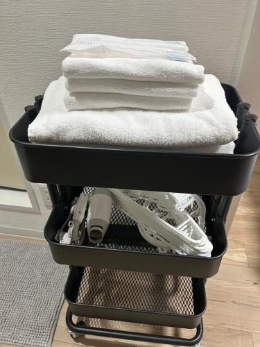 a black basket filled with towels and towels at SABBATH uzumasa 102 in Kyoto