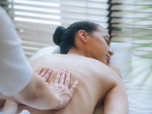 a woman laying on a bed with her back at The Terrace Club Wellness Thalasso At Busena in Nago