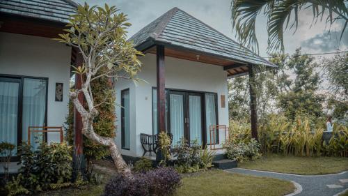a house with a tree in front of it at Umahita Lodge Penida in Toyapakeh