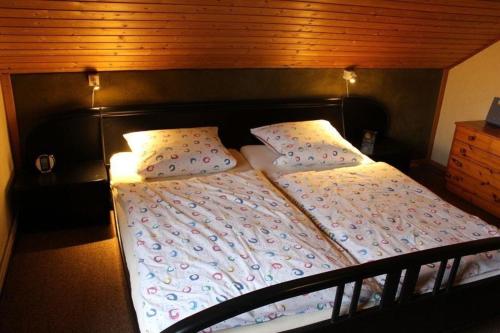 a bed with a wooden headboard and pillows on it at Ferienhaus 008 in Tossens in Stick