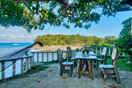 a table and chairs with a view of the ocean at Pilar Pilapil Beach House in Malapascua in Daanbantayan