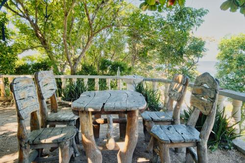 a wooden table and chairs sitting next to a fence at Pilar Pilapil Beach House in Malapascua in Daanbantayan