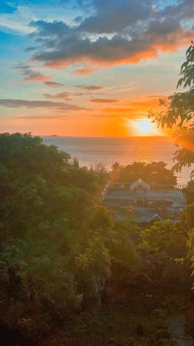 a sunset over the ocean with the sun in the sky at Pilar Pilapil Beach House in Malapascua in Daanbantayan