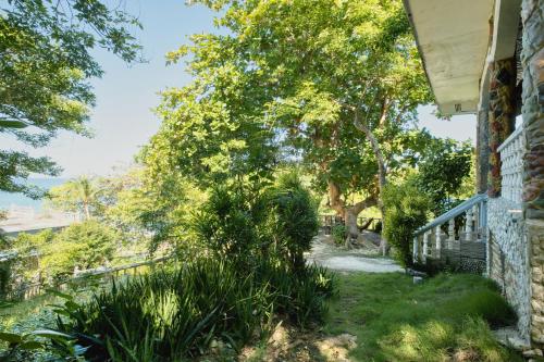 a house with a yard with grass and trees at Pilar Pilapil Beach House in Malapascua in Daanbantayan
