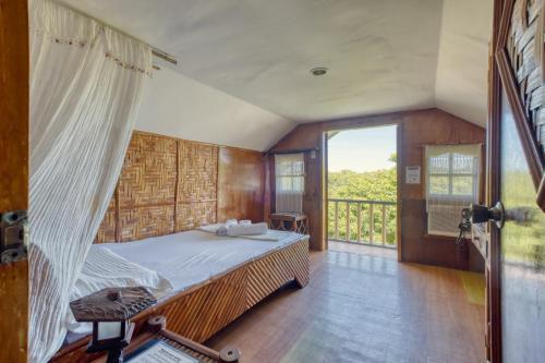 a bedroom with a bed and a balcony at Pilar Pilapil Beach House in Malapascua in Daanbantayan