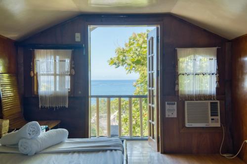 a bedroom with a view of the ocean at Pilar Pilapil Beach House in Malapascua in Daanbantayan