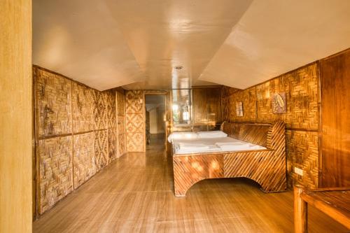 a room with two beds in a room with wooden walls at Pilar Pilapil Beach House in Malapascua in Daanbantayan