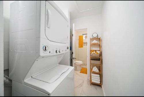 a white dishwasher in a white kitchen next to a bathroom at House in the Heart Of Miami in Miami