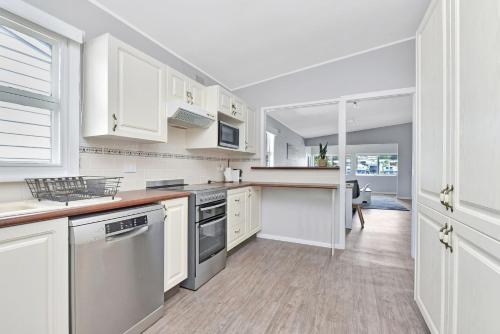 a kitchen with white cabinets and a counter top at Balmoral Waterfront Escape at Lake Macquarie in Balmoral