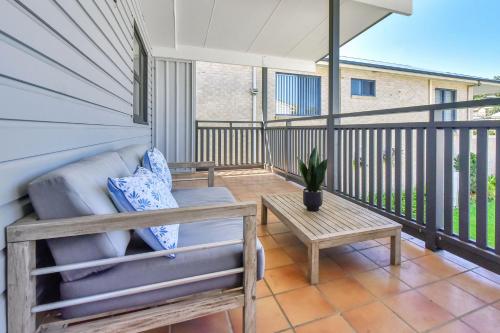 a porch with a couch and a table on a balcony at Balmoral Waterfront Escape at Lake Macquarie in Balmoral