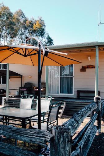a table and chairs with an umbrella on a patio at Glenview Alpaca Farm in Yass