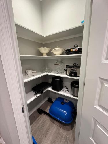 a pantry with white shelves and a blue container at Premier Luxe Villa in Weslaco