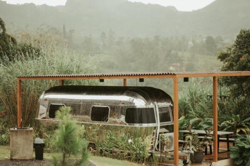 a rusted out trailer sitting in a garden at Campgrounds at Mantalongon in Dalaguete