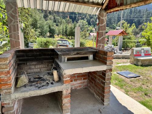 an outdoor brick oven with a grill at Cabaña Cedros Mineral del Chico in Mineral del Chico